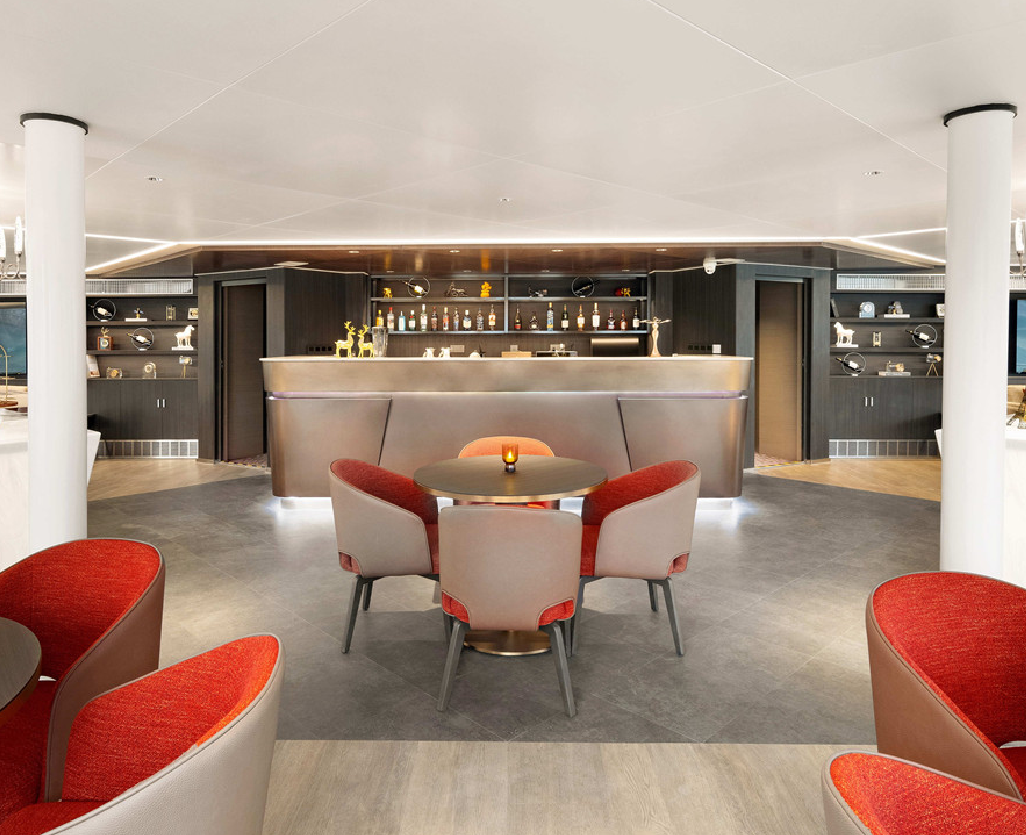 邮轮豪华舱室内部，双人床铺整洁，大窗户面向江景，装饰典雅